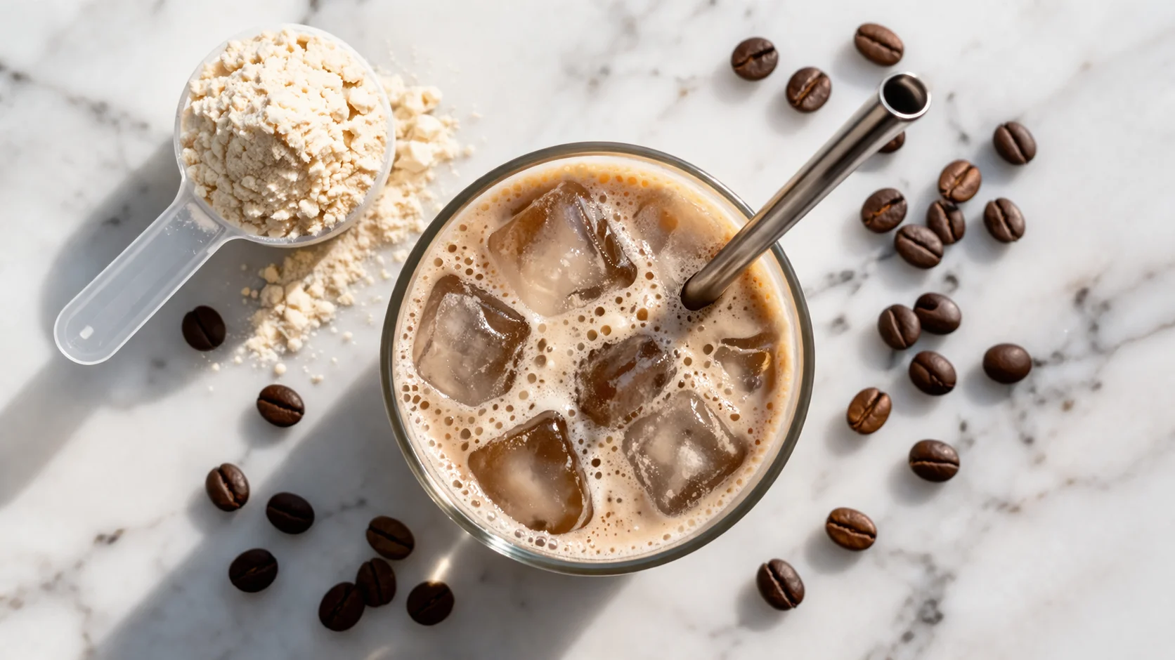 Vue de dessus d'un café protéiné glacé vanille dans un verre transparent, scoop de protéine et grains de café autour